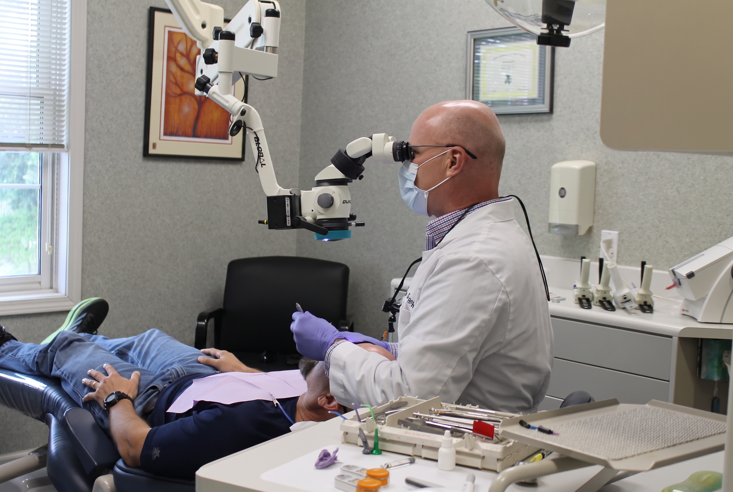 Dr. Nigel Morgan treating a patient with a dental microscope in his Hendersonville, NC office