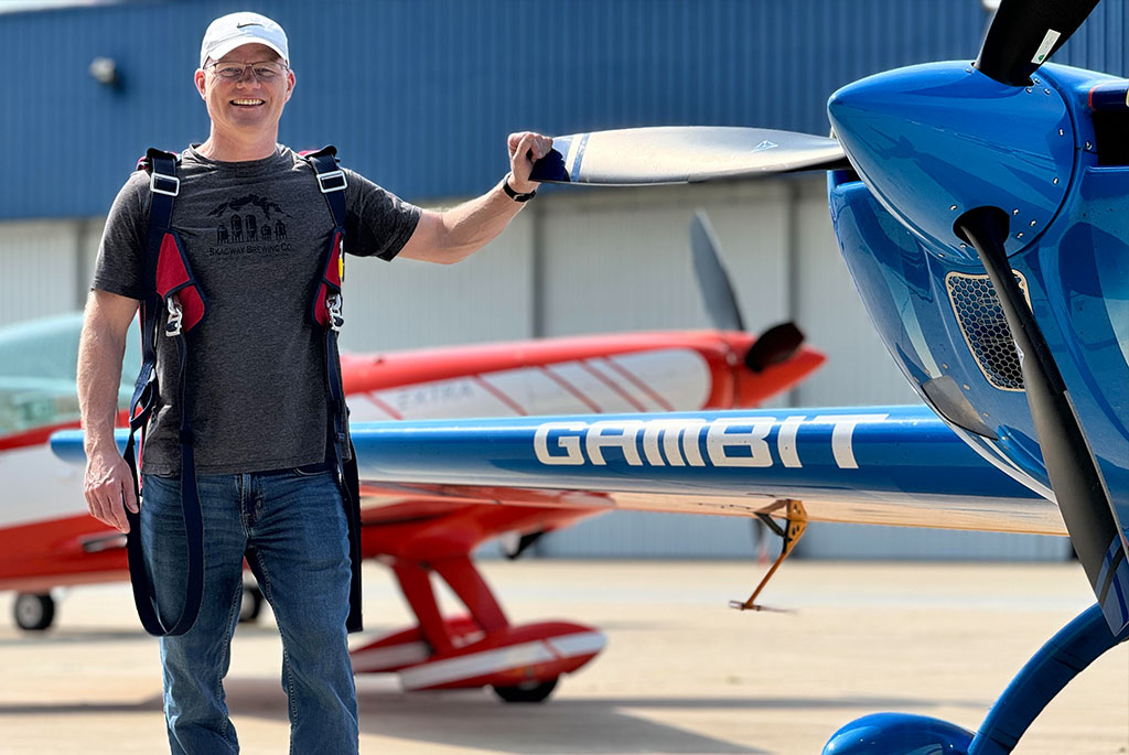 Dr. Nigel Morgan standing beside his personal aircraft